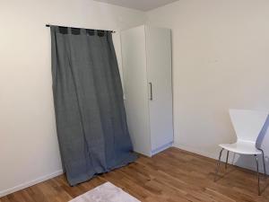 a room with a gray curtain and a white cabinet at Comfort Us in Uppsala +6 photos