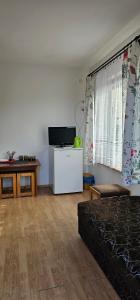 a living room with a couch and a flat screen tv at Pokoje U Wandy in Łeba