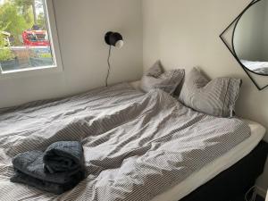 a bed with a blanket and pillows in a bedroom at Tiny house in Uttran, Stockholm in Uttran