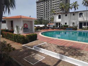a swimming pool with a building in the background at Town House El Retiro in Porlamar