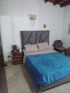 a bedroom with a large bed with a blue blanket at Town House El Retiro in Porlamar +8 photos