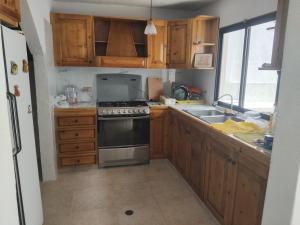 a kitchen with wooden cabinets and a stove top oven at Town House El Retiro in Porlamar