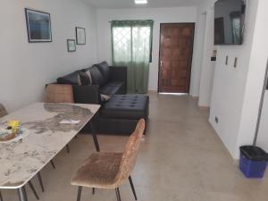a living room with a table and a couch at Town House El Retiro in Porlamar