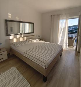 a bedroom with a large bed and a large window at Apartments Laus in Zavalatica