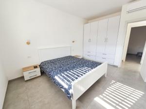 a white bedroom with a bed and white cabinets at המקום של אסי - Assi's place in Oshrat