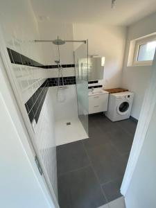 a bathroom with a shower and a washing machine at La grange du clos in Angiens +20 photos