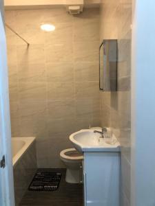 a bathroom with a sink and a toilet and a tub at Oakbridge Studios in Burnley +12 photos