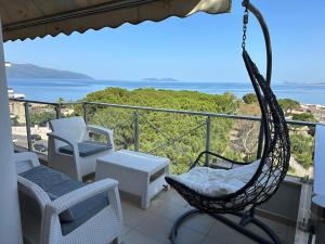 a hammock on a balcony with a view of the ocean at Suite Apartment Vlorë in Vlorë