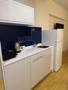 a white kitchen with a sink and a refrigerator at ORBI CITY amazing holiday in Batumi