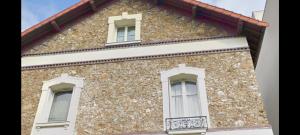 un edificio in pietra con due finestre e un balcone di apart 94160 studio a Saint-Mandé