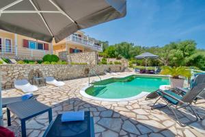 a swimming pool with chairs and an umbrella at Villa Avgerini Paxos in Gaios