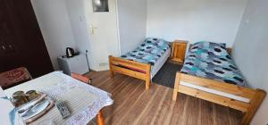 a small room with two beds and a table at Pokoje U Wandy in Łeba