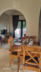 a dining room with a wooden table and chairs at Chez Gigi, Maisonnette tout confort avec terasse in Beuvry +6 photos