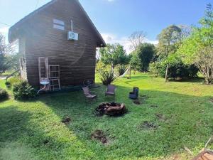 een huis met een vuurplaats in de tuin bij Cabana do Lago in Nonoai