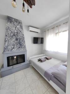 a bedroom with a bed and a fireplace at Anthos Rooms Vrasna in Nea Vrasna