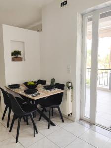 a dining room with a table and black chairs at Anthos Rooms Vrasna in Nea Vrasna