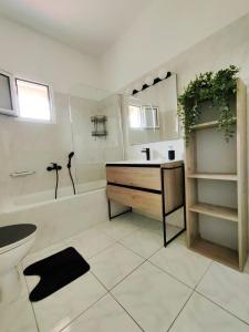 a bathroom with a tub and a sink and a toilet at Anthos Rooms Vrasna in Nea Vrasna +28 photos
