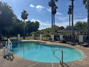 a swimming pool with palm trees and a gazebo at Wingate by Wyndham Biloxi - Ocean Springs in Biloxi
