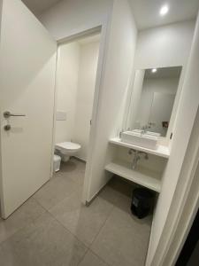 a bathroom with a sink and a toilet and a mirror at SENSI - glampingtenten midden in de bossen in Oostkamp +8 photos