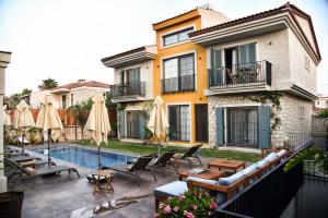 a villa with a swimming pool next to a building at Soas Suites in Alacati