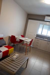 a room with a table and chairs and a kitchen at TSABAS BEACH SIDE APARTMENTS ΤΣΑΜΠΑΣ ΠΑΡΑΛΙΑΚΑ Διαμερίσματα 4 in Kyllini +13 photos