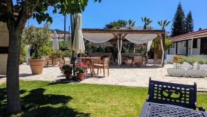 a patio with a table and chairs and an umbrella at Villa Karina in Kolios
