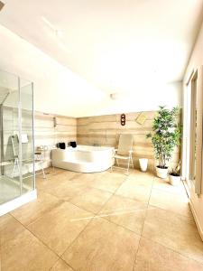 La grande salle de bains est pourvue d'une baignoire, d'une table et de chaises. dans l'établissement Villa Grande Kalkan, à Kaş