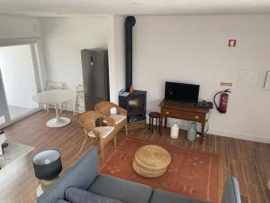 a living room with a blue couch and a tv at Casa Da Concha in Almograve