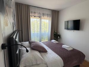 a bedroom with a bed with a television on the wall at HORIZON Privlaka3 in Privlaka +22 photos