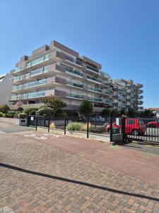 a large apartment building with a red truck in front of it at Le B - A 200 m de la plage in Arcachon