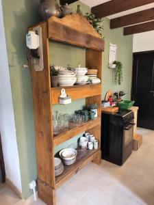 a wooden shelf with bowls and dishes in a kitchen at Gîtes à la ferme, Le Jardin Bleu in Tulette +10 photos