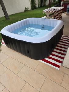Un gran jacuzzi con una alfombra roja y blanca. en Au Grés du Vent, en Ruy