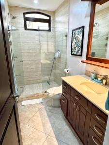 Un baño con ducha, inodoro y lavabo. en Costa Rican Jaco Haven, en Jacó