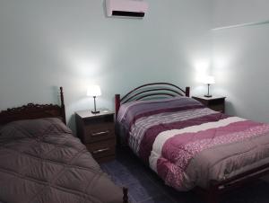 a bedroom with two beds and two lamps on tables at Departamento El Inca 2 in Fiambala