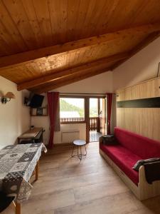 un salon avec un canapé rouge et une table dans l'établissement OLCA Les Houches, aux Houches