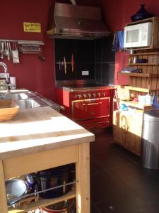 a kitchen with red cabinets and a counter in it at Maison côté ouest in Groix