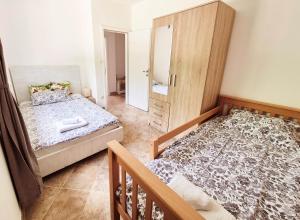 een kleine slaapkamer met twee bedden en een spiegel bij Villa AveKalu in Opric