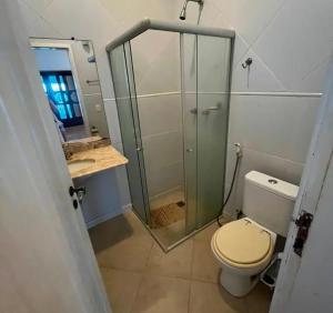 a bathroom with a toilet and a glass shower at Casarão da Barra - Barra De Cunhaú in Canguaretama +7 photos