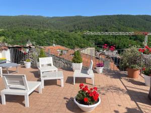 a group of white chairs on a patio with flowers at LA Stanzetta in Assergi