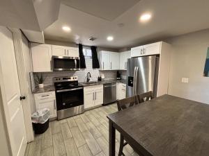 a kitchen with white cabinets and a table and a refrigerator at Gorgeous 2-King-Bed Lower Unit in Denver in Denver +10 photos