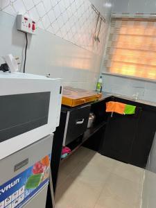 イケジャにあるStay Well Homes Comfortinnの小さなキッチン(カウンター、カウンタートップ付)