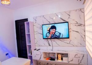 イケジャにあるStay Well Homes Comfortinnの大理石壁の壁掛けテレビ