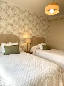 a bedroom with two beds and a wall at Betalia II in Caldas de Reis