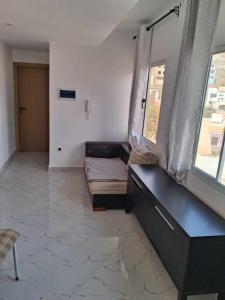 a living room with a couch and two windows at Casa da Sara Guest House in Mindelo