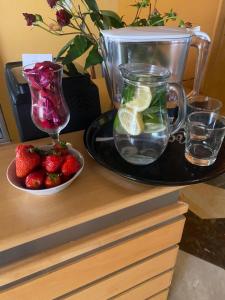 a table with a plate of strawberries and a blender at Hotel FLÓRA retro in Dudince