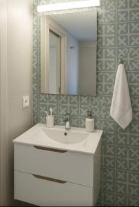Un baño con un lavabo blanco y un espejo. en Thalassa loft in Tolo, en Tolo