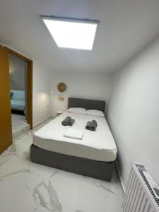 a white bedroom with a bed with a skylight at The Secret Studio - OAKA Stadium & nearby hospitals in Athens