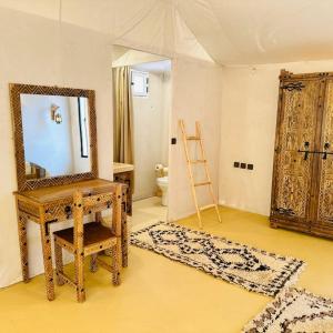 Una habitación con un espejo, un tocador y una escalera. en Africa Luxury Camp, en Merzouga
