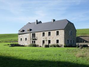 ein großes Steinhaus auf einem Grasfeld in der Unterkunft Lovely Holiday Home in Mettet with Garden in Stave