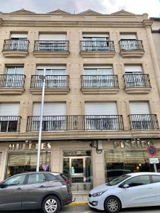 two cars parked in front of a building at Betalia II in Caldas de Reis